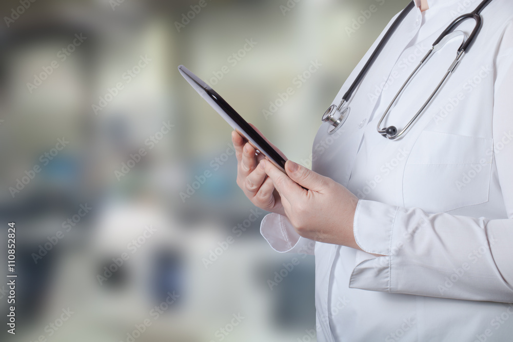 A woman in a white uniform robe with electronic device in her ha A woman in a white uniform robe with electronic device in her ha
