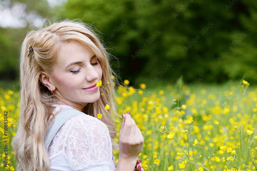 Beautiful blonde is smelling flowers Beautiful blonde is smelling flowers