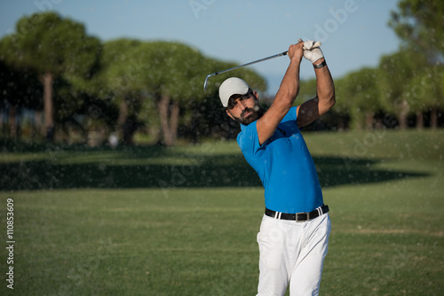 pro golfer hitting a sand bunker shot