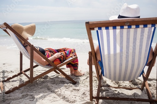 Fotografie Happy senior couple relaxing on deckchairs at beach