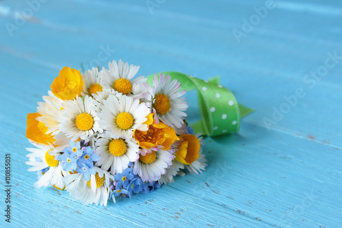 Fototapeta Naklejka Na Ścianę i Meble -  Blumenstrauß mit selbst gepflückten Blumen, Gänseblümchen, Sumpfdotterblume, Vergissmeinnicht  auf blauem Holz
