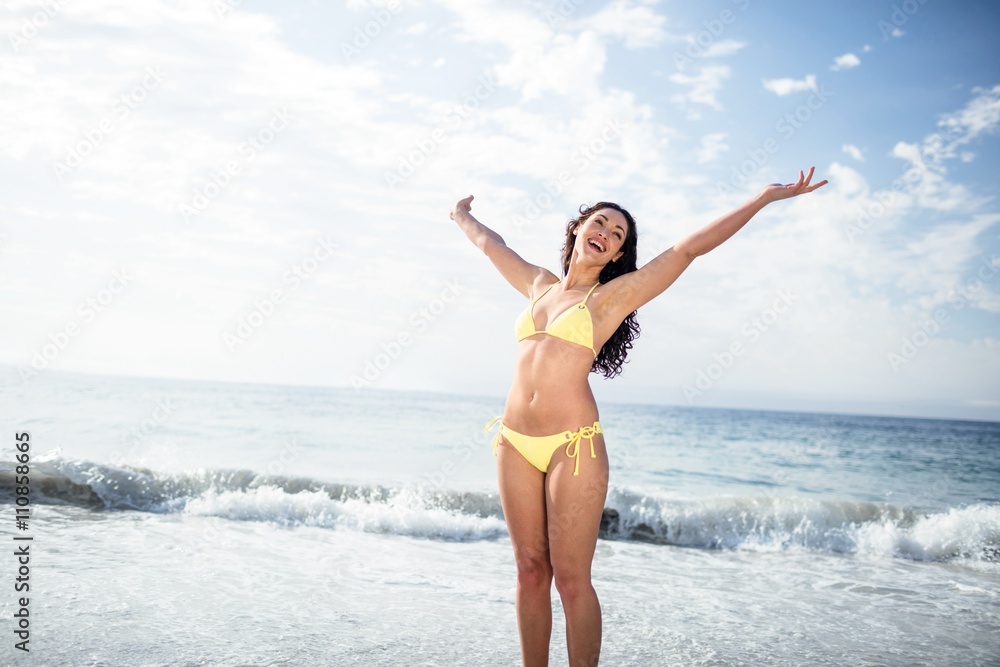 Carefree woman in bikini standing on the beach Carefree woman in bikini standing on the beach