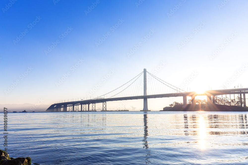 tranquil water and gold gate bridge at sunrise