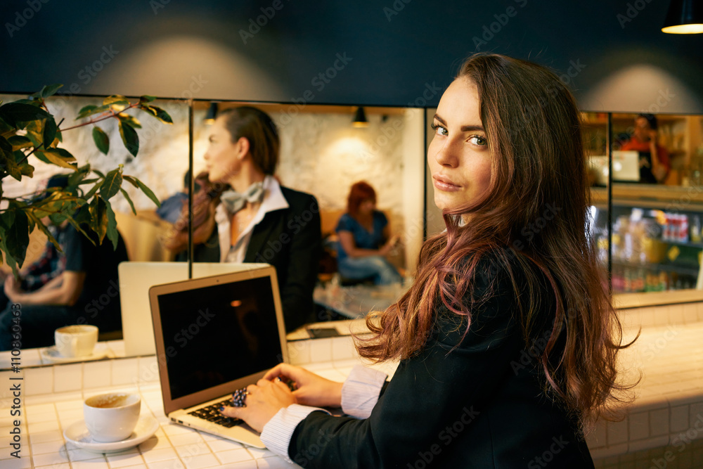 Young modern business woman sitting in front open net-book with copy space screen for your text or content. Female freelancer using a laptop for distance job. focus on a face. Young modern business woman sitting in front open net-book with copy space screen for your text or content. Female freelancer using a laptop for distance job. focus on a face.