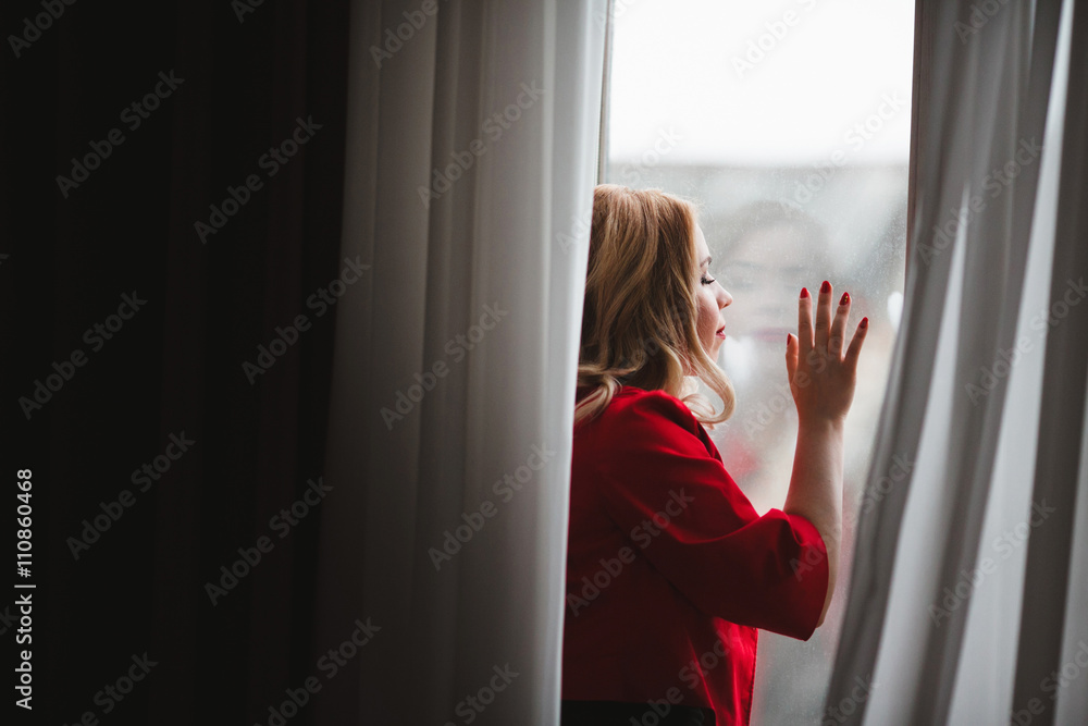 beautiful young lady enjoying the view from the window