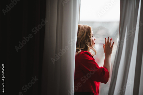 beautiful young lady enjoying the view from the window