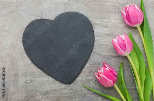 Fototapeta Naklejka Na Ścianę i Meble -  Herzförmige Schiefertafel mit pinken Tulpen
