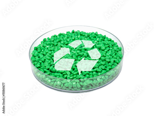 Grünes PET-Granulat in Petrischale mit Recycling-Symbol (Rohstoff; Recycling; Umwelt) 