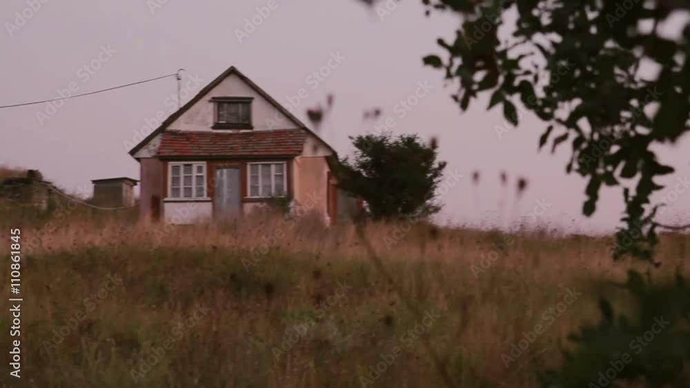 Lonely rural house standing on the hill at sunset. Dolly shot. Lonely rural house standing on the hill at sunset. Dolly shot.