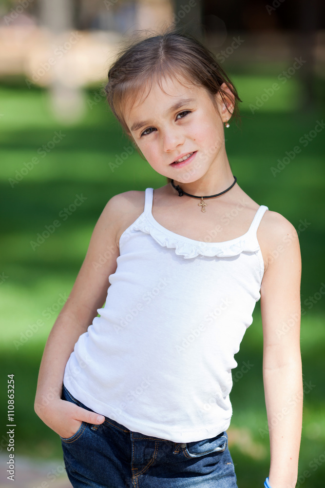 Happy girl standing on the lawn in the park Happy girl standing on the lawn in the park