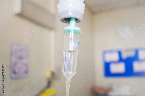 hand holding saline IV drip for patient in hospital room