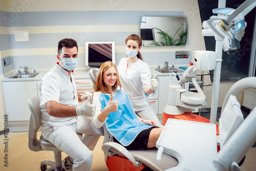 Young smiled woman with doctors at the dental office