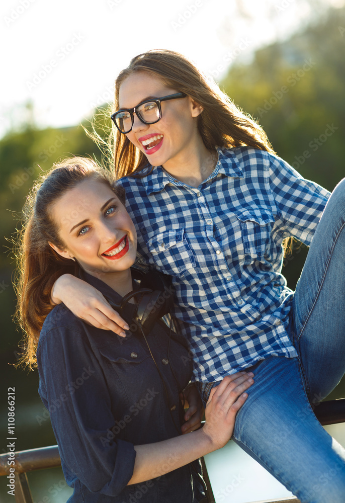 Fototapeta premium Two playful young girl having fun outdoors at sunset light