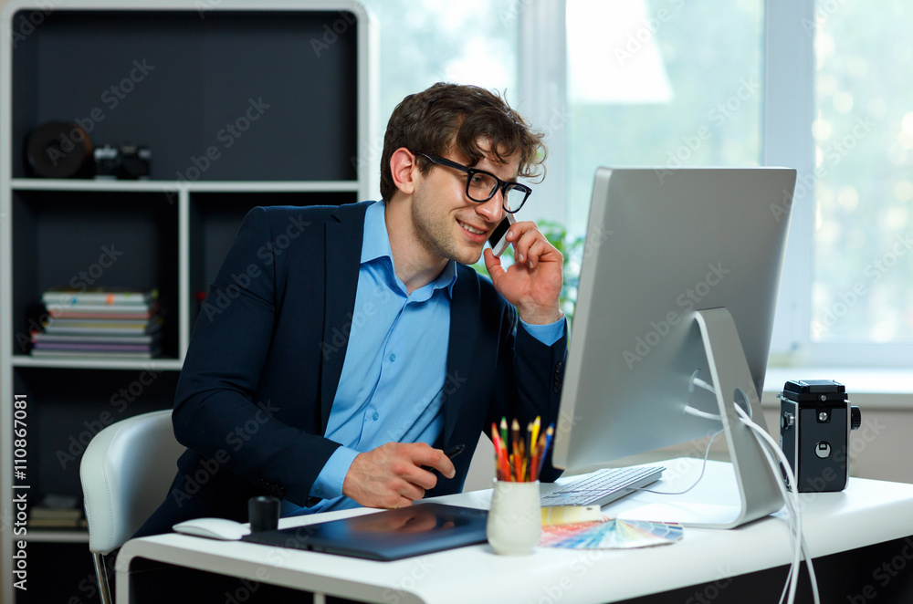 Naklejka premium Handsome young man working from home office and using smartphone