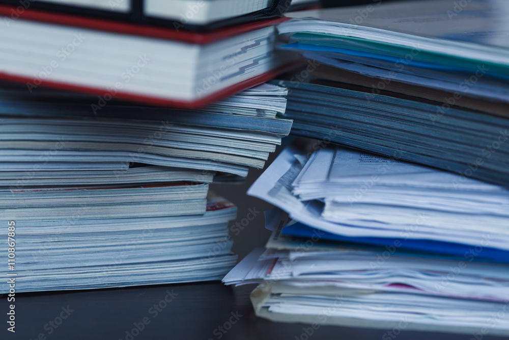 Accounting and taxes. Pile of magazine, notebook and books close Accounting and taxes. Pile of magazine, notebook and books close