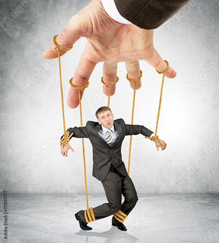 Obraz na plátně Businessman hanging on strings like marionette