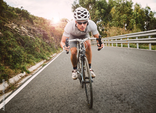 Cyclist pedaling on a racing bike outdoor photo