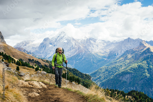 Man tourist with a backpack walking mountain trails in the Dolomite, Alps