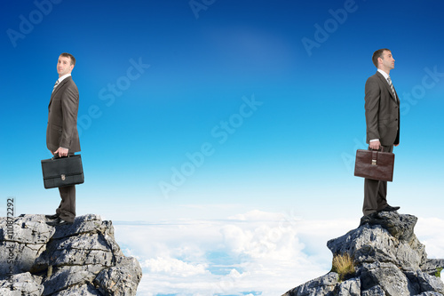 Businessmen standing on peaks 