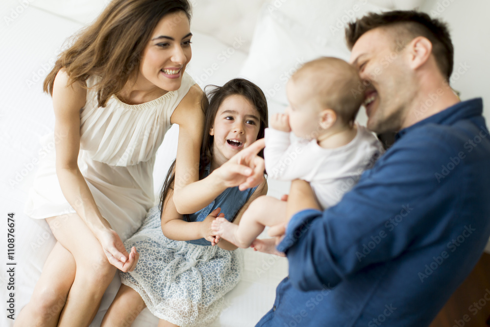 Parents with a little girl and a baby on the bed Parents with a little girl and a baby on the bed