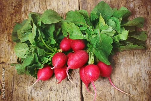 Fresh radishes on old wooden table