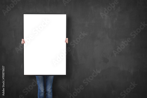 woman holding a poster over a blackboard