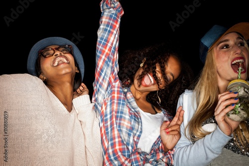 Young women side by side arms raised smiling photo