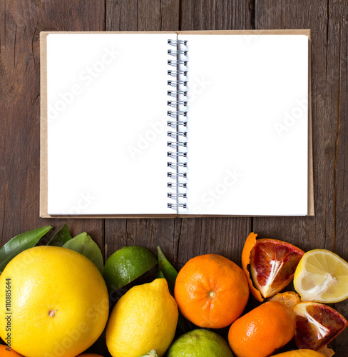 Fresh citrus fruits with cnotebook photo