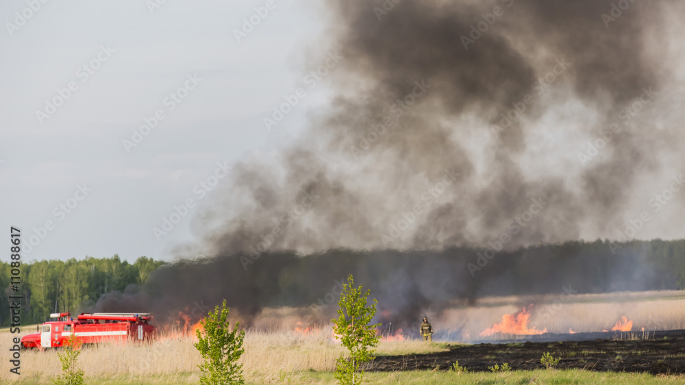 Fototapeta premium CHELYABINSK, RUSSIA - May 15, 2015: fire truck puts out in a field a forest fire