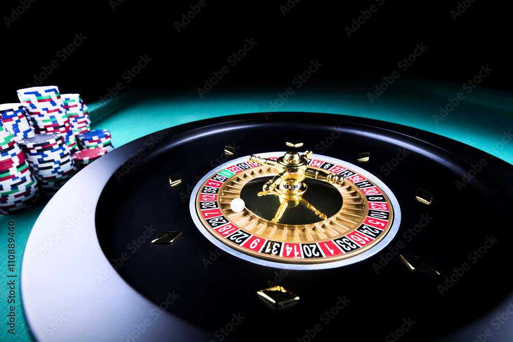 casino theme, high contrast image of casino roulette and playing chips on green canvas casino theme, high contrast image of casino roulette and playing chips on green canvas
