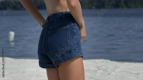 Slim girl remove denim shorts on a beach Stock Video | Adobe Stock