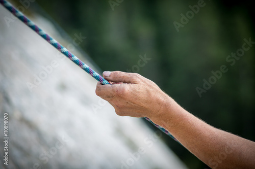 Climber holding a rope on a stone wall