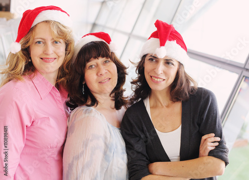 Portrait of three beautiful real women wearing christmas hat