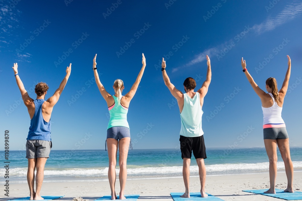 People doing yoga on the beach People doing yoga on the beach
