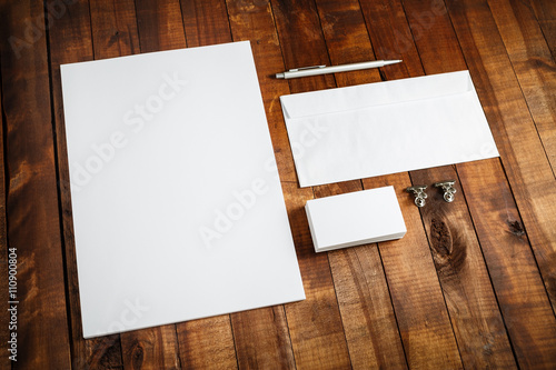 Photo of blank stationery set on wooden background. Template for design presentations and portfolios. Letterhead, business cards, envelope and pen.