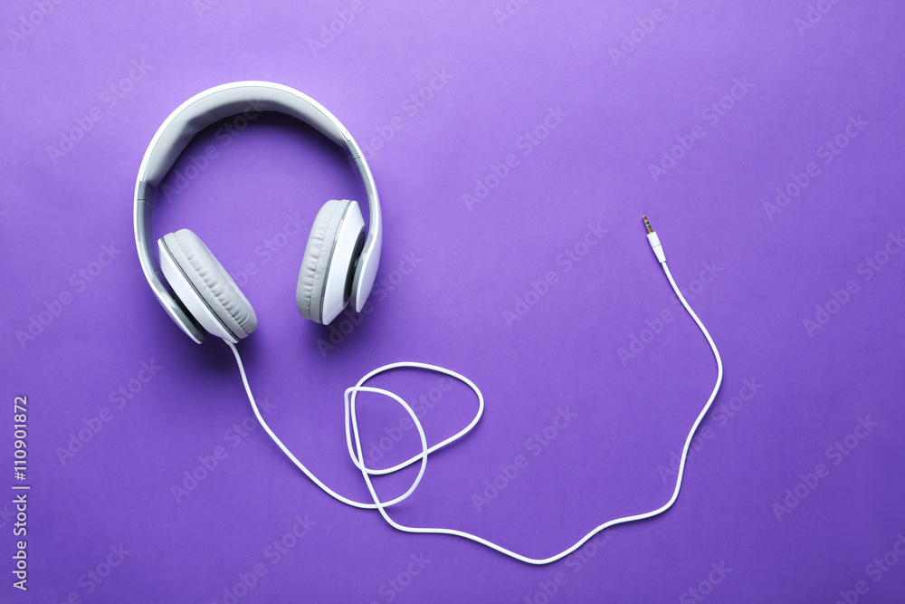 Headphones on a purple paper background, close up Headphones on a purple paper background, close up