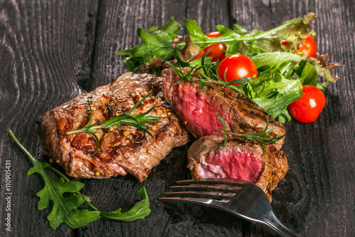 steak and salad on a wooden table