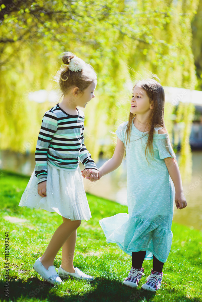Fototapeta premium cute stylish little girls playing at park outdoor