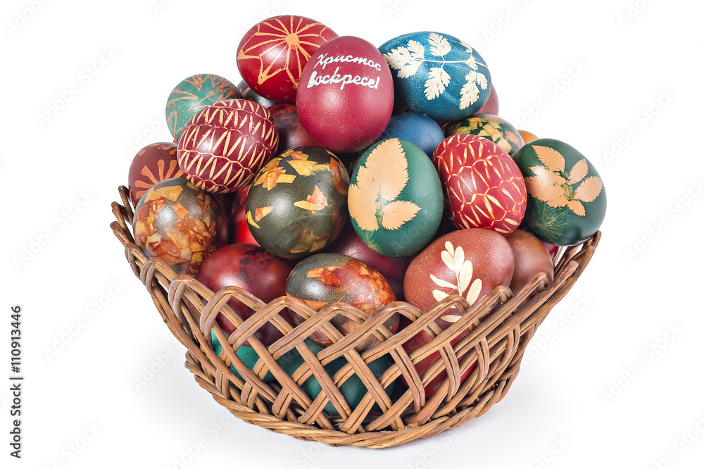 Fototapeta premium Easter eggs in woven basket isolated on white background