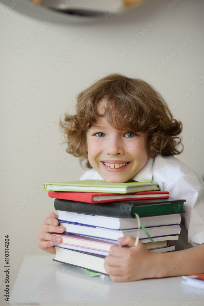 The boy presses his chest stack of books The boy presses his chest stack of books