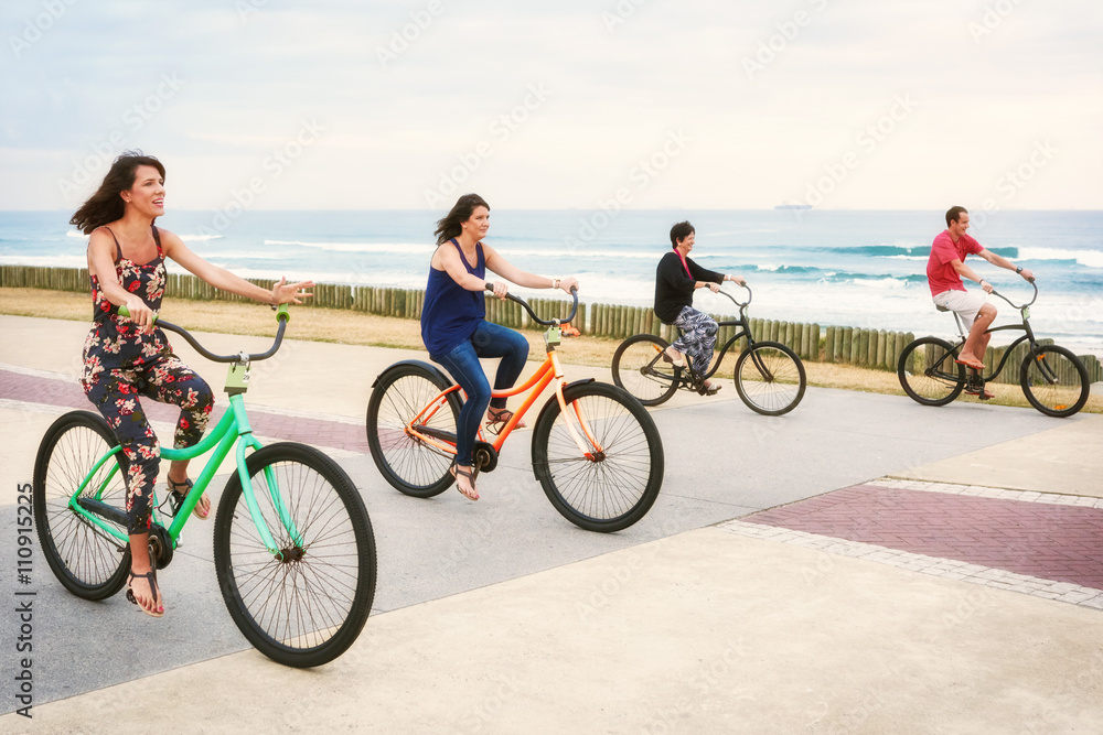 Fototapeta premium Mother cycling with her three children on the promenade