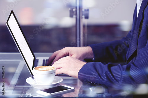 Businessman having lunch and working in cafe, close-up