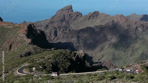 Touristic bus and cars drive narrow road TF-436. Mountain zig-zag road TF-436 from Masca village to Santiago del Teide. Tenerife, Spain
