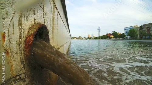 Waste water to city canal. Industrial pipe discharging liquid waste.
