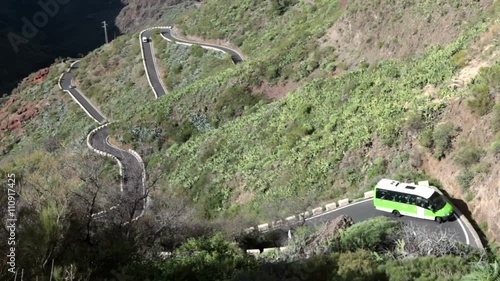 Passenger bus drives on mountain zig-zag road TF-436 from Masca village to Santiago del Teide. Tenerife, Spain
