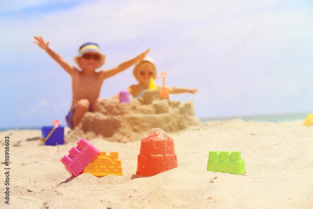 little boy and toddler girl play with sand on beach little boy and toddler girl play with sand on beach