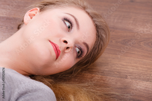 Young cheerful lady lying on floor.