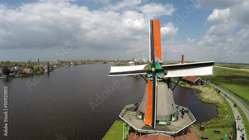 Aerial static bird view of one of windmills of Zaanse Schans one of most popular tourist attractions Netherlands Holland near Amsterdam beautiful drone footage tourists on mill blades turning 4k