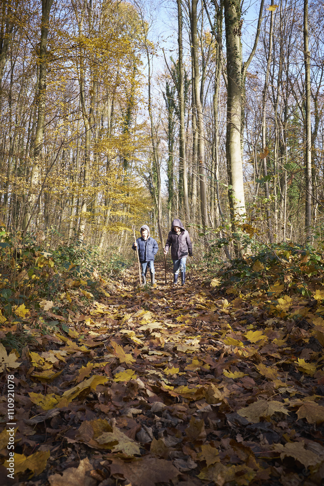 Two boys walking through woods Two boys walking through woods