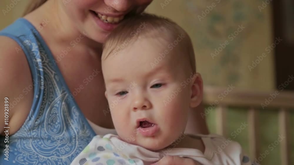 Happy baby boy sitting on his mother's lap. Happy baby boy sitting on his mother's lap.